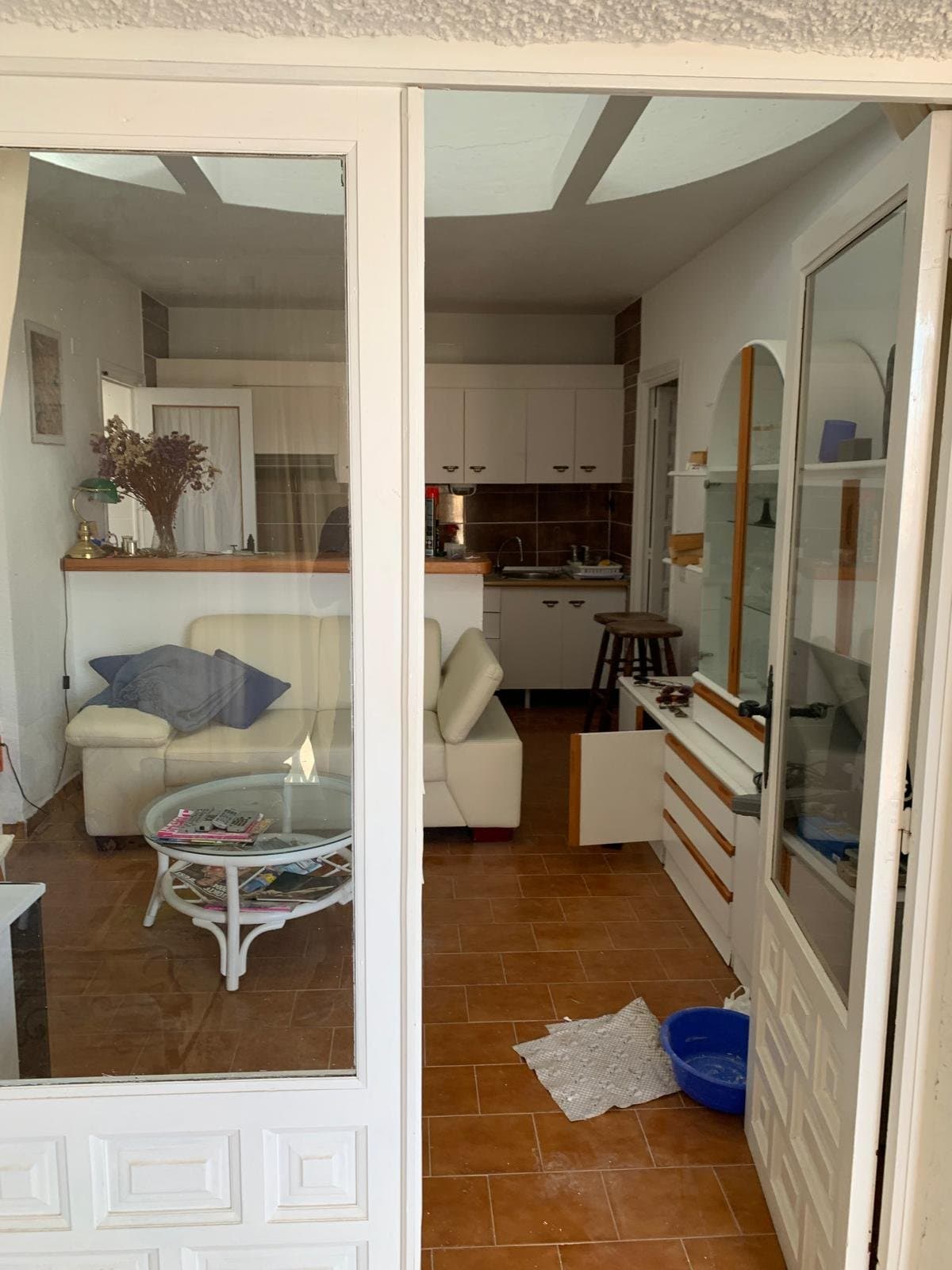 Le salon et la cuisine avant, vus à travers les anciennes portes vitrées
