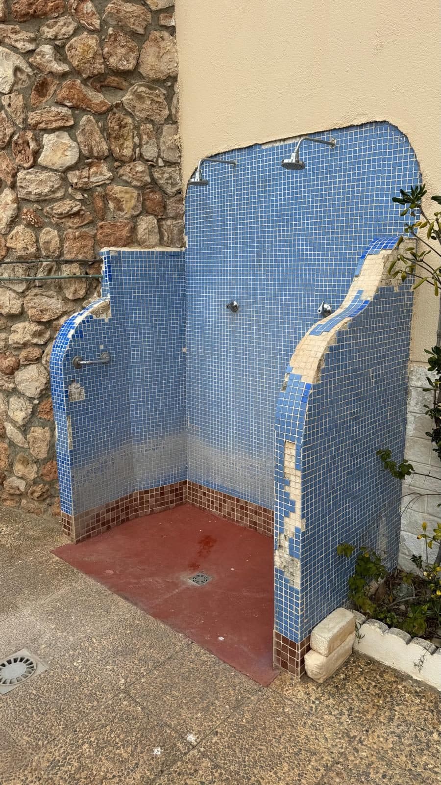 Die alte Dusche mit kaputten Fliesen
