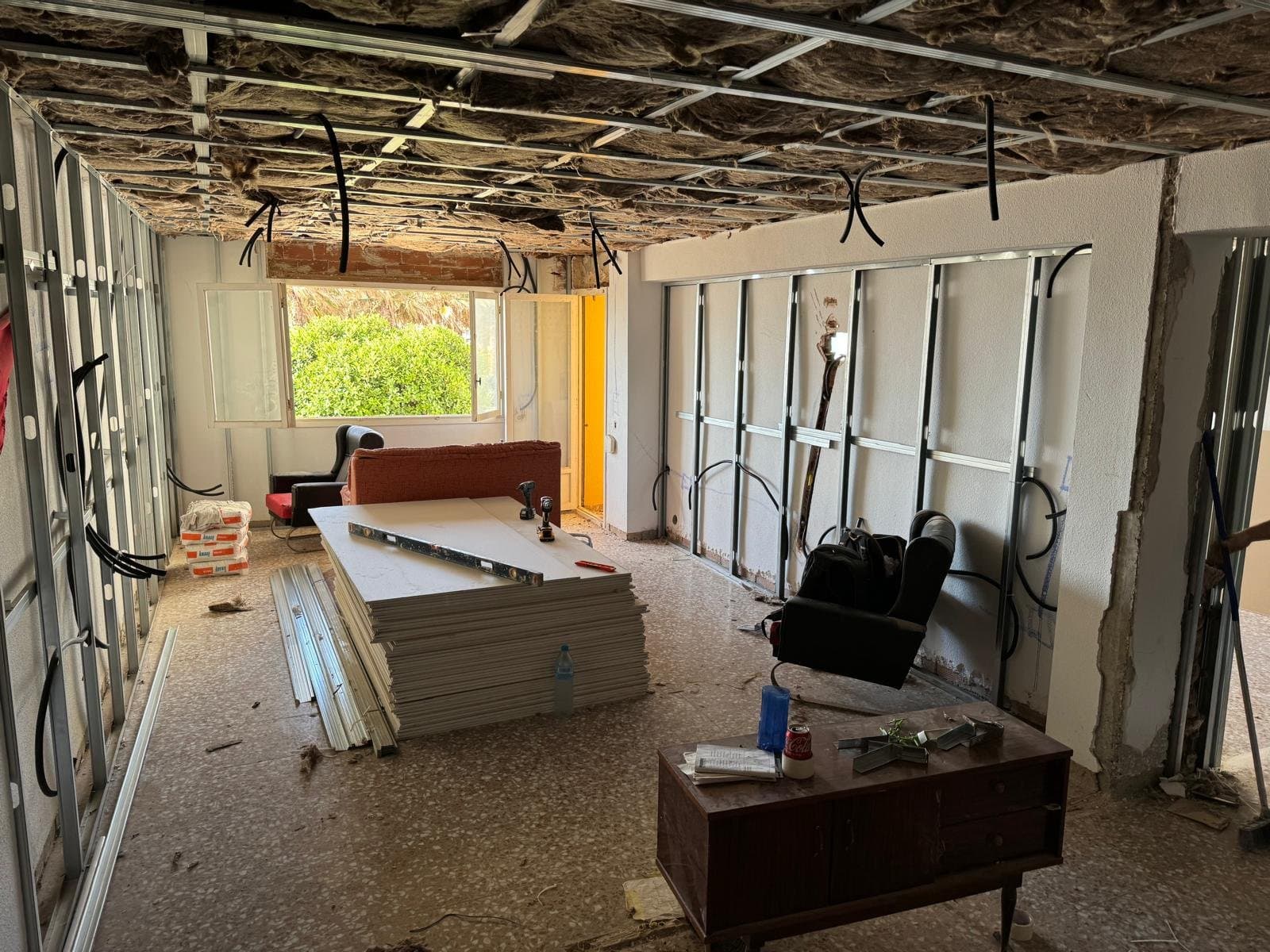 A sala durante a obra, com estruturas nas paredes e isolamento por cima